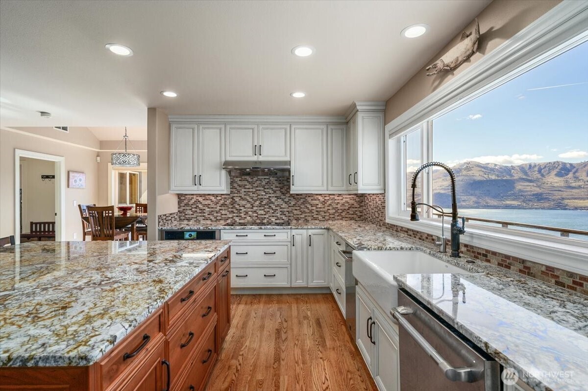 333 Highpoint Place Chelan, WA 98816 - Photo 13 of 40 an open kitchen with granite countertop kitchen island stainless steel appliances a sink stove and cabinets