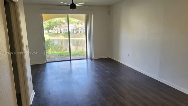 a view of a room with wooden floor and a window