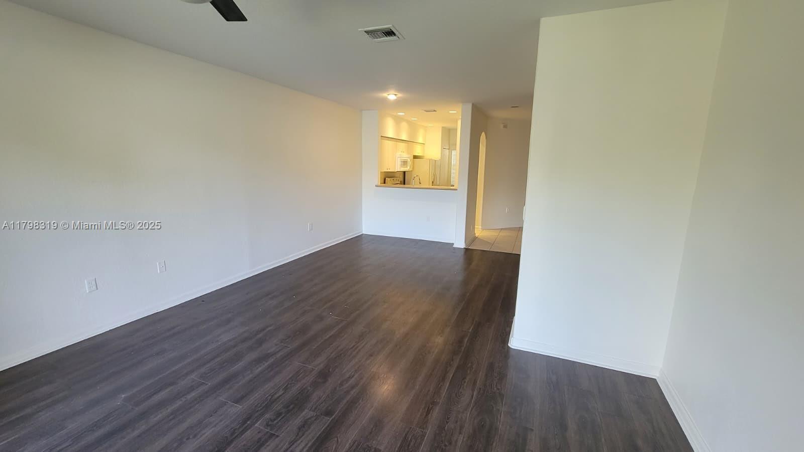 8353 Southwest 26 Th Street, Unit 104 Miramar, FL 33025 - Photo 14 of 14 a view of an empty room with wooden floor and a window