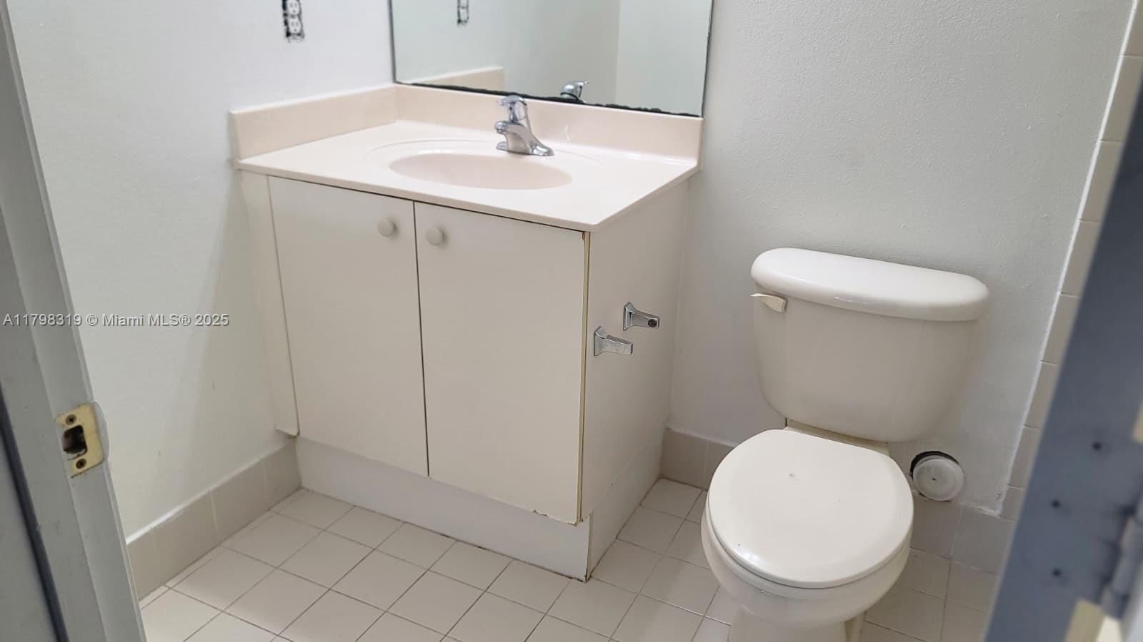8353 Southwest 26 Th Street, Unit 104 Miramar, FL 33025 - Photo 6 of 14 a bathroom with a sink a toilet and a mirror