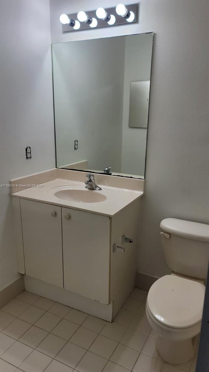 8353 Southwest 26 Th Street, Unit 104 Miramar, FL 33025 - Photo 7 of 14 a bathroom with a toilet sink and mirror