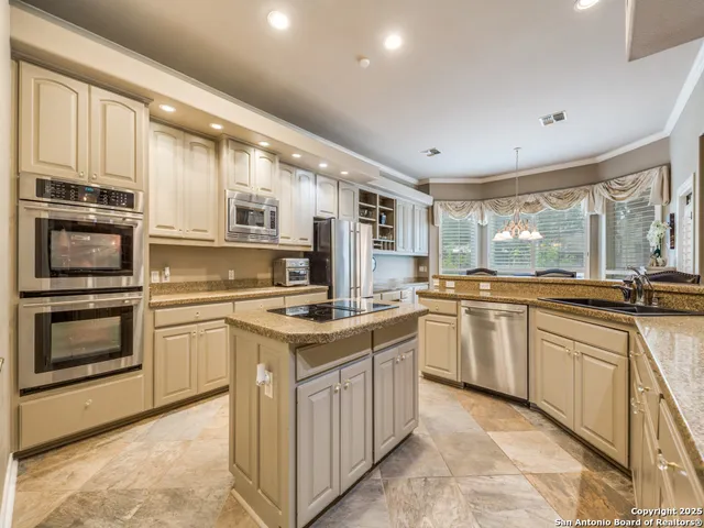a kitchen with stainless steel appliances granite countertop a stove and cabinets
