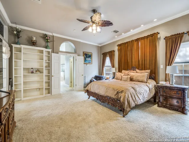 a spacious bedroom with a bed and a chandelier