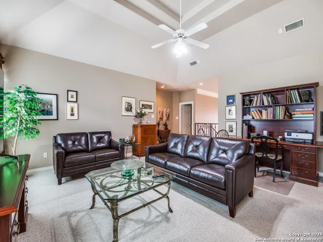 a living room with furniture a chandelier and a potted plant