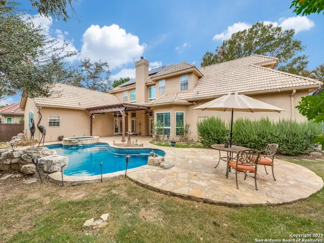 a view of a house with backyard and sitting area