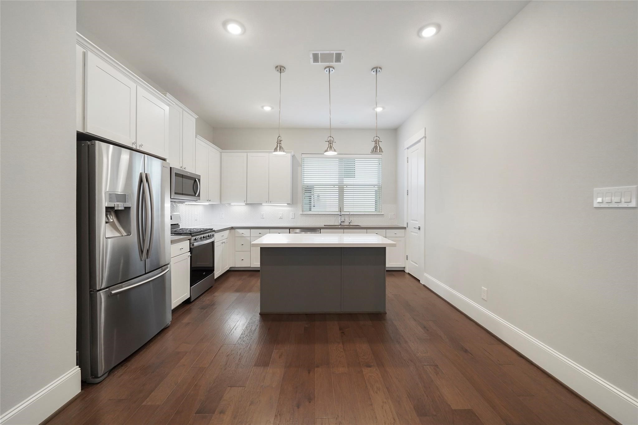 1268 North Post Oak Road, Unit A Houston, TX 77055 - Photo 12 of 32 a kitchen with kitchen island a sink stainless steel appliances and cabinets
