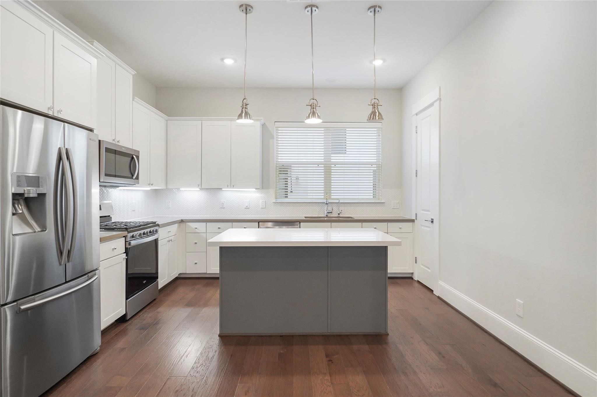 1268 North Post Oak Road, Unit A Houston, TX 77055 - Photo 13 of 32 a kitchen with kitchen island granite countertop a sink cabinets and stainless steel appliances