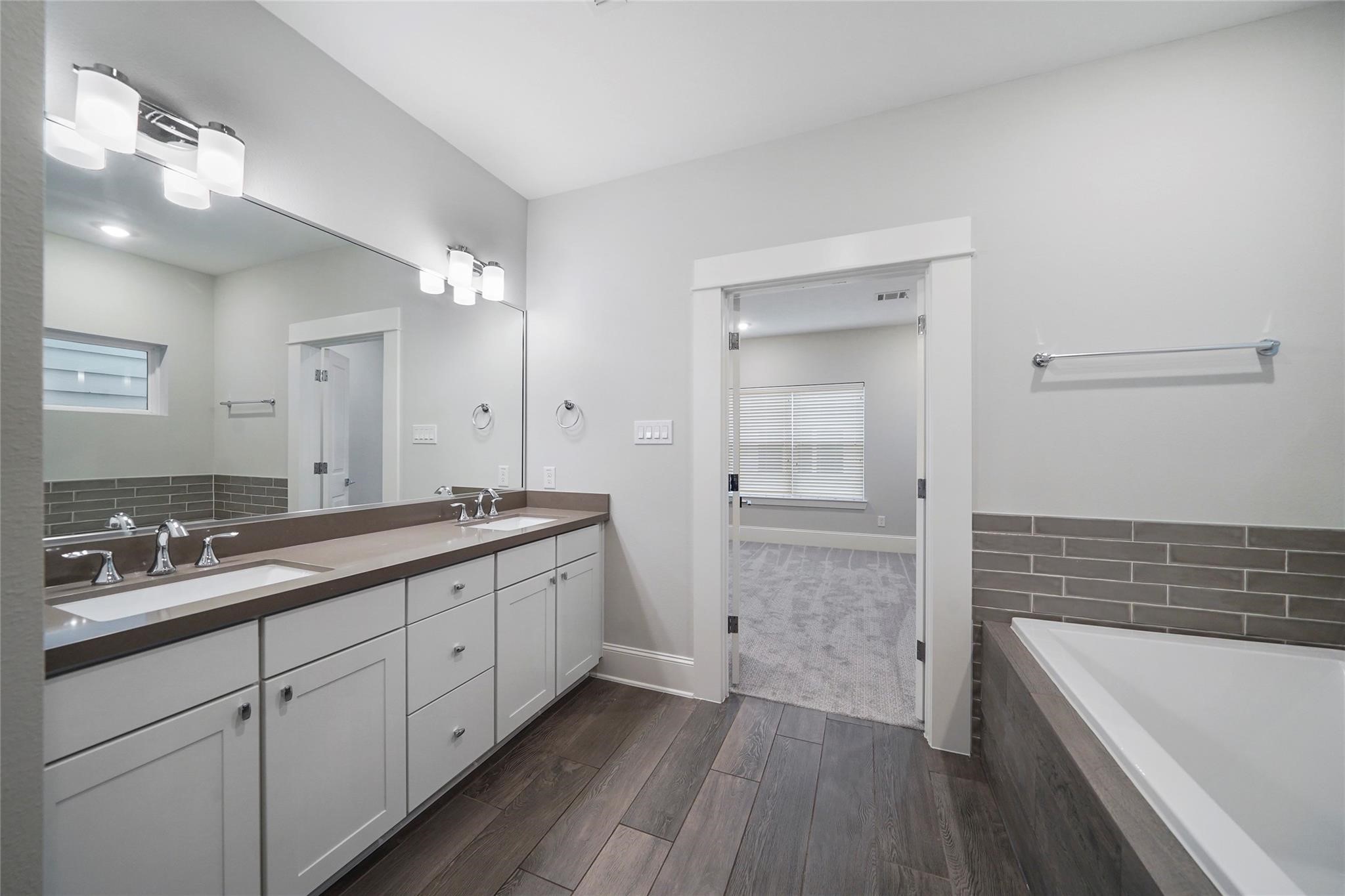 1268 North Post Oak Road, Unit A Houston, TX 77055 - Photo 27 of 32 a spacious bathroom with a double vanity sink a mirror and a bathtub