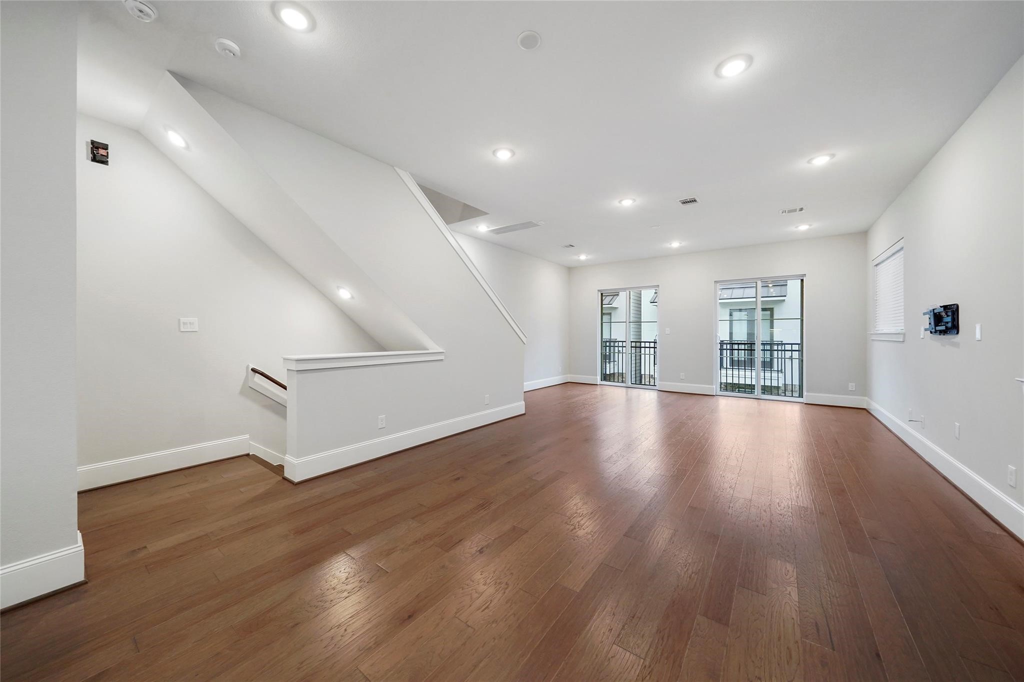 1268 North Post Oak Road, Unit A Houston, TX 77055 - Photo 4 of 32 an empty room with wooden floor staircase and windows