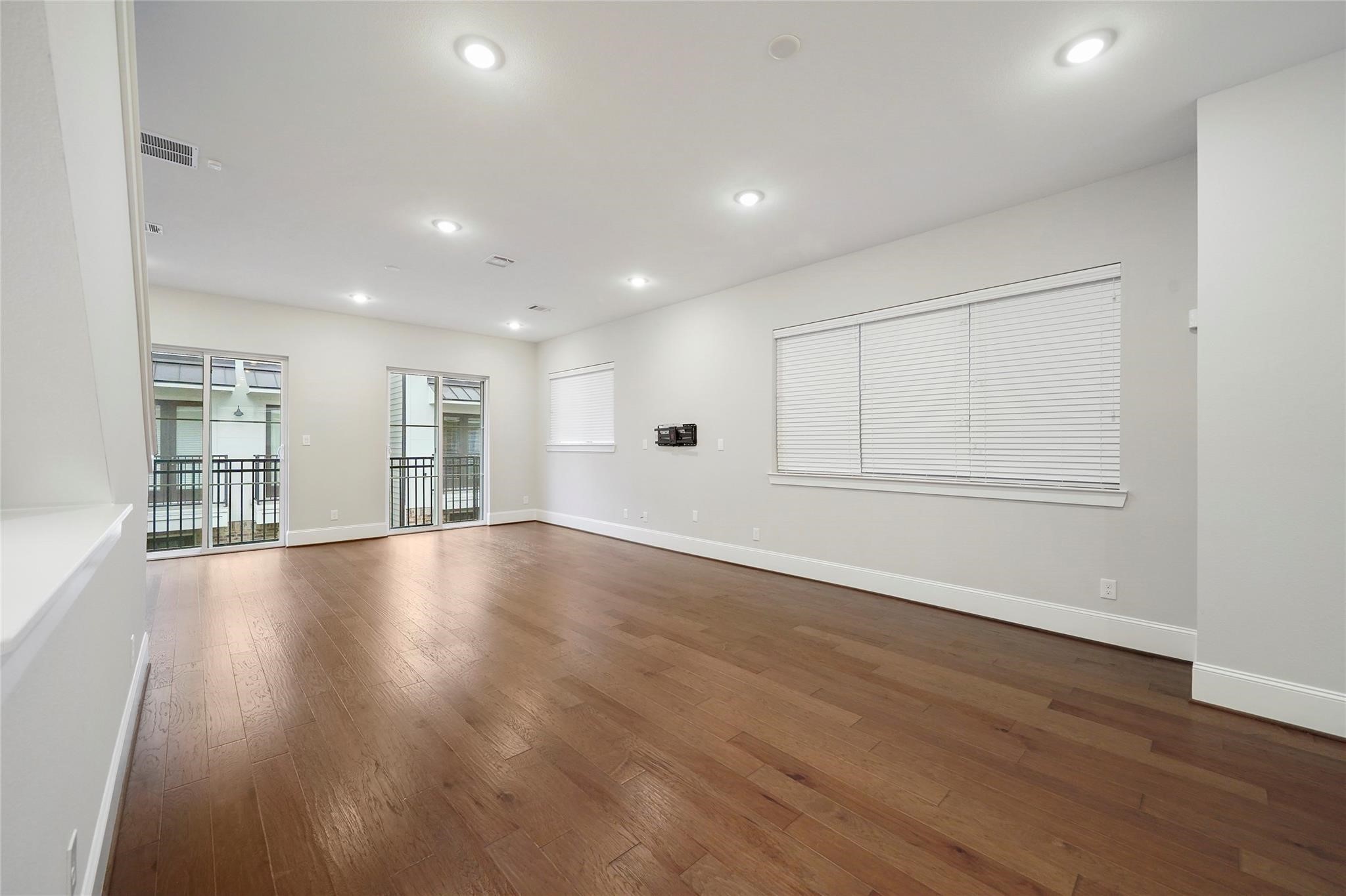 1268 North Post Oak Road, Unit A Houston, TX 77055 - Photo 7 of 32 an empty room with wooden floor and windows