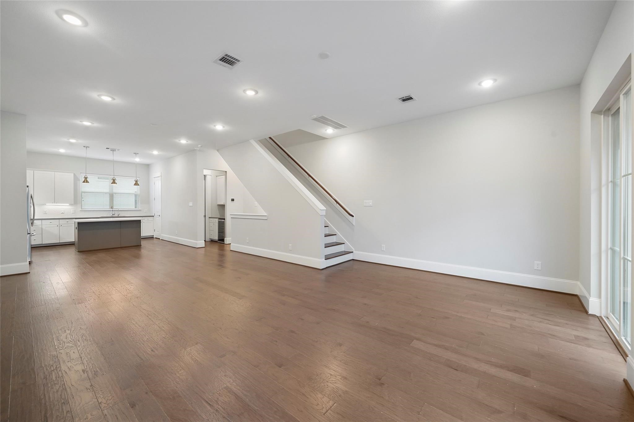 1268 North Post Oak Road, Unit A Houston, TX 77055 - Photo 8 of 32 a view of an empty room with wooden floor and kitchen