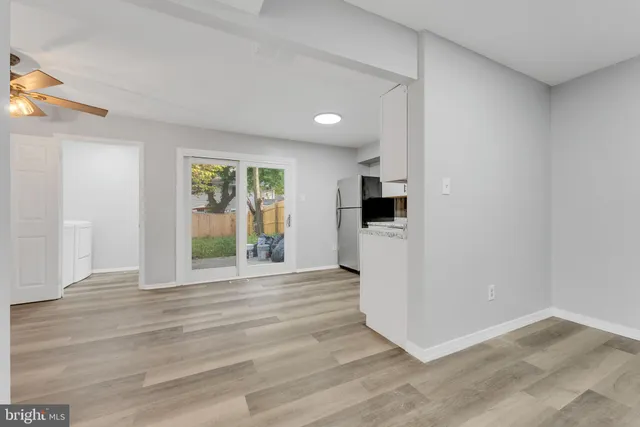 a view of a kitchen with wooden floor and a refrigerator