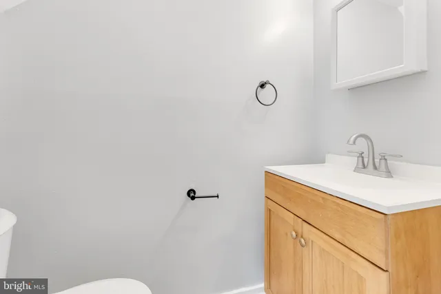 a bathroom with a sink mirror vanity and toilet