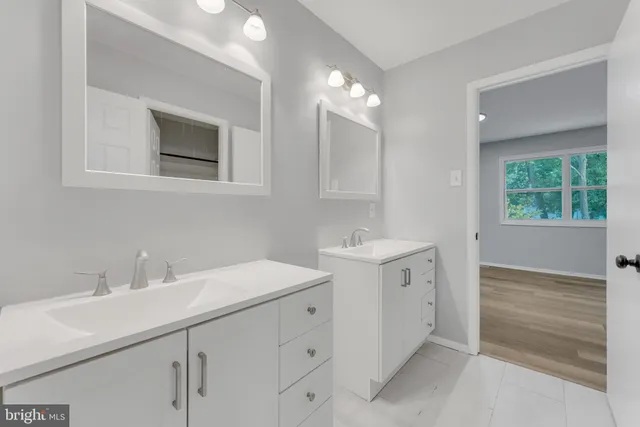 a bathroom with a double vanity sink a and a window