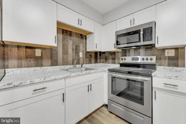 a kitchen with stainless steel appliances granite countertop a stove microwave and cabinets