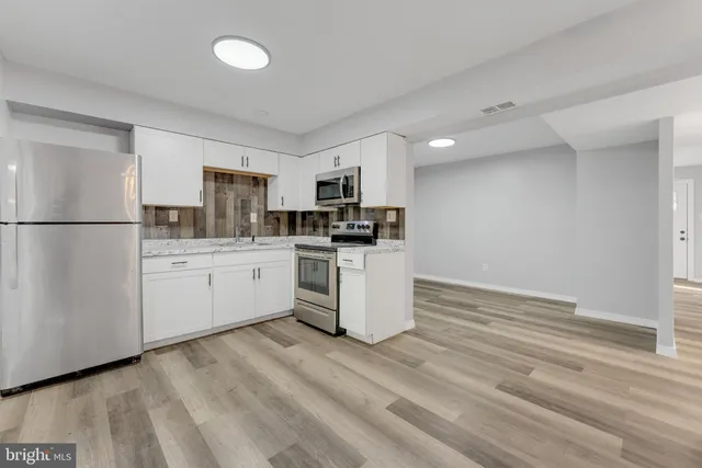 a kitchen with white cabinets and white appliances