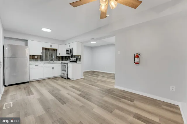a kitchen with a refrigerator and a stove top oven