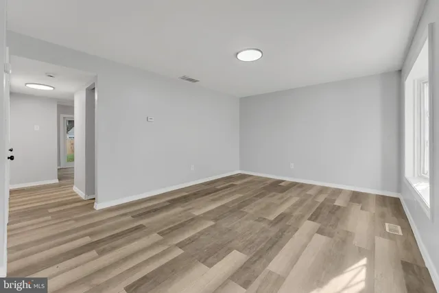 a view of empty room with wooden floor
