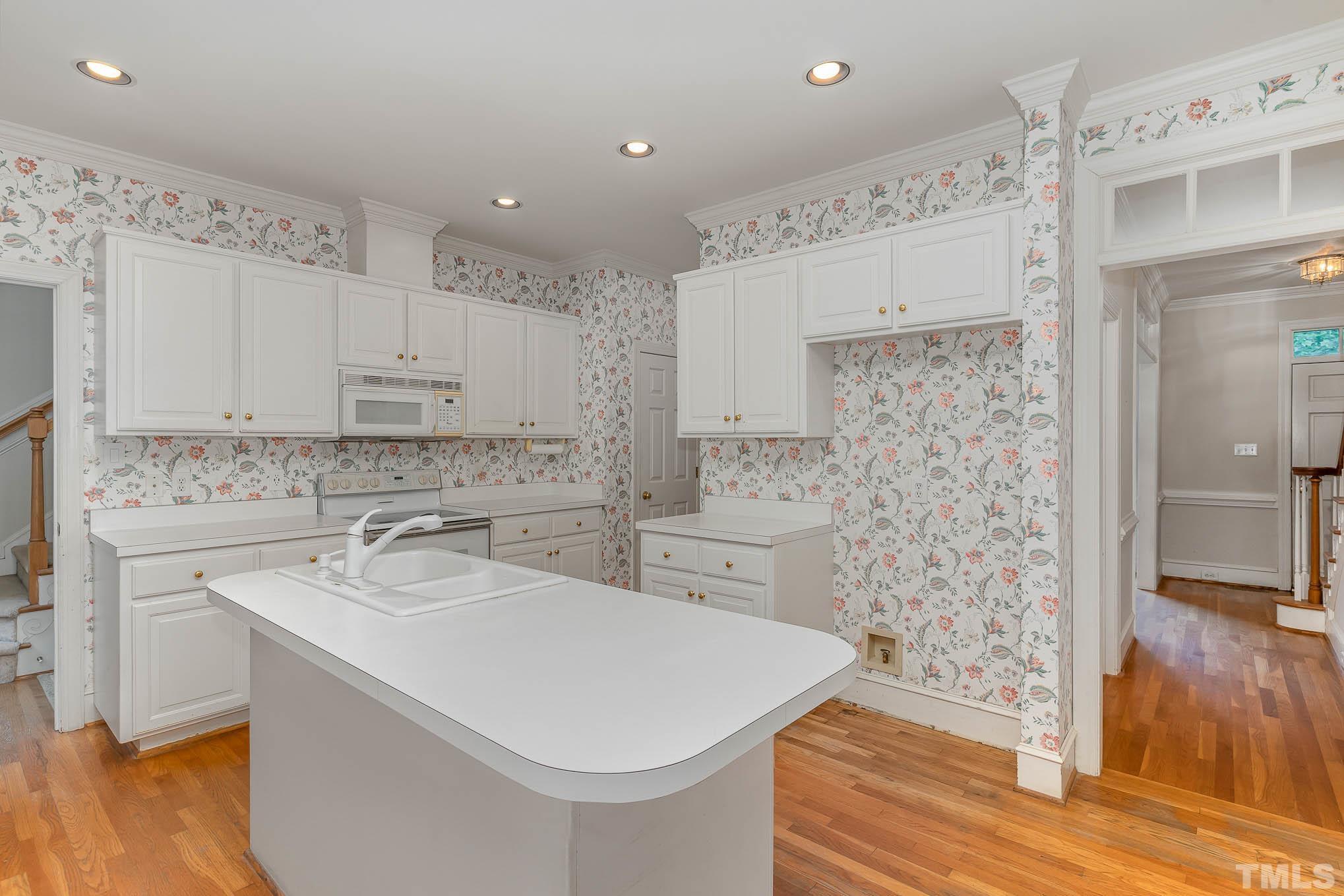 8121 Glenbrittle Way Raleigh, NC 27615 - Photo 14 of 35 a kitchen with a sink a stove a refrigerator and white cabinets