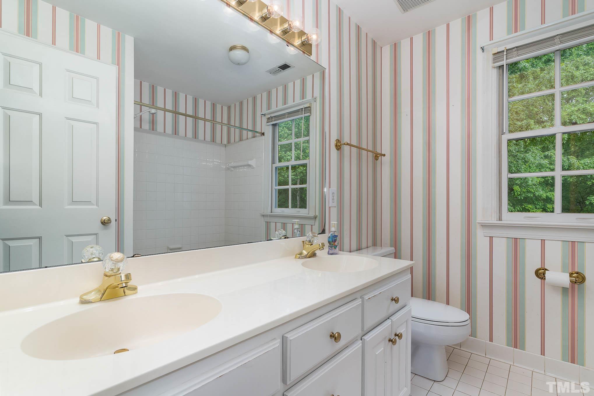 8121 Glenbrittle Way Raleigh, NC 27615 - Photo 21 of 35 a bathroom with a double vanity sink toilet and a tub