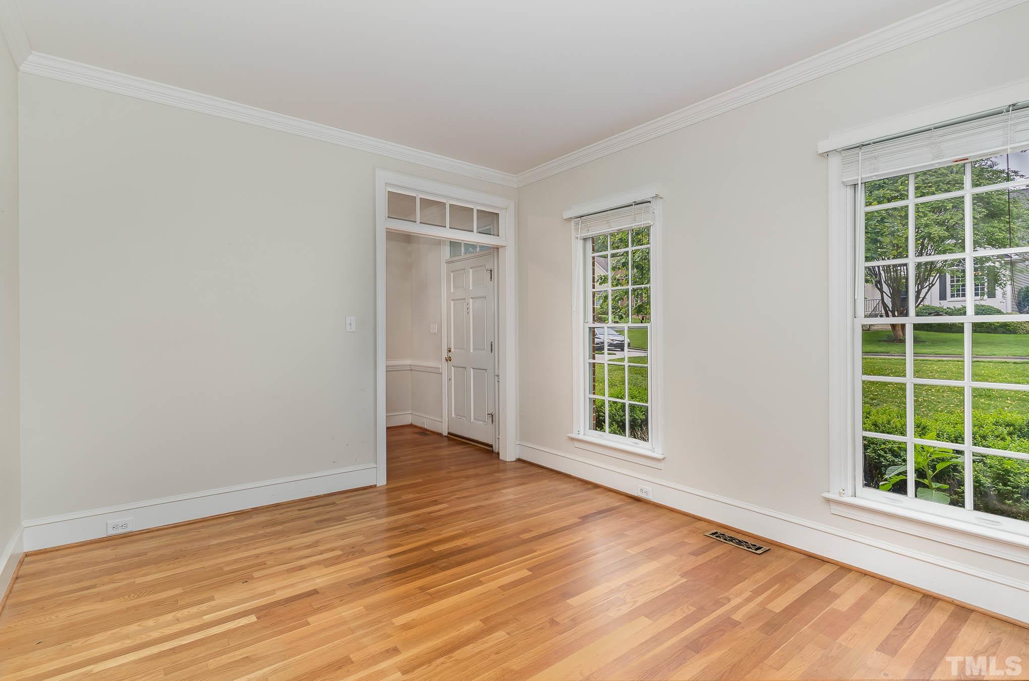 8121 Glenbrittle Way Raleigh, NC 27615 - Photo 7 of 35 an empty room with wooden floor and windows