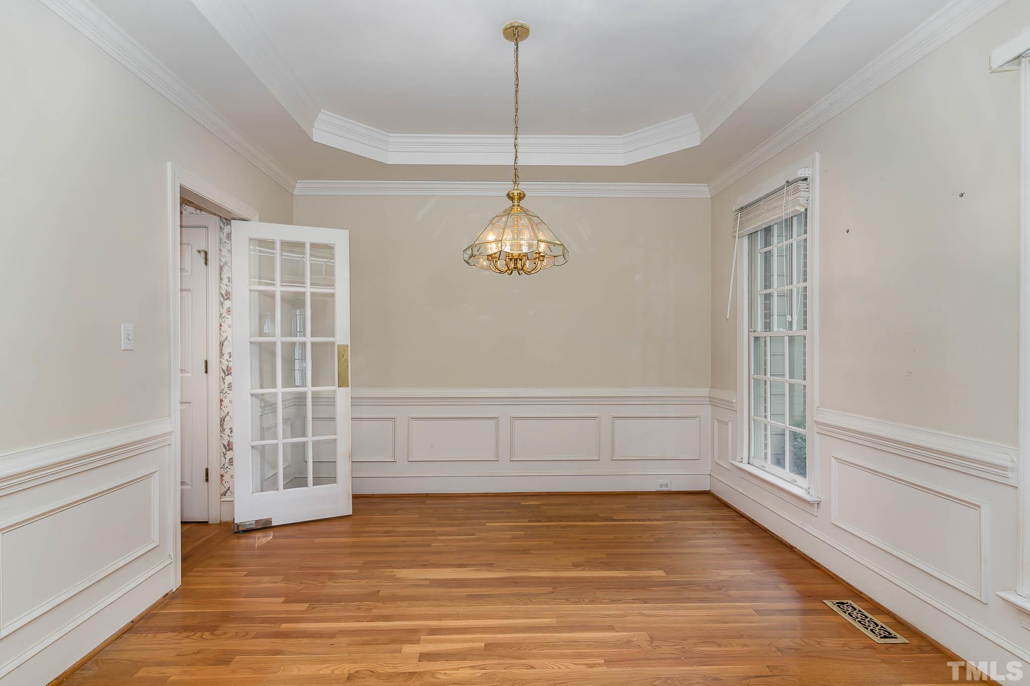 8121 Glenbrittle Way Raleigh, NC 27615 - Photo 8 of 35 a view of an empty room with wooden floor and windows