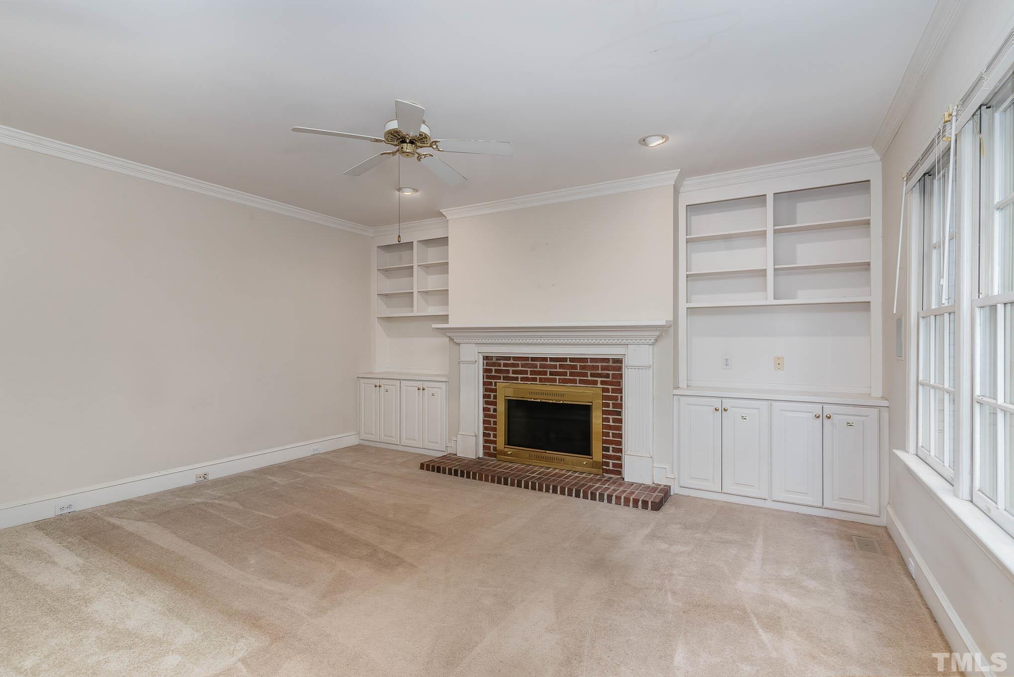 8121 Glenbrittle Way Raleigh, NC 27615 - Photo 9 of 35 a view of an empty room with a fireplace and a window