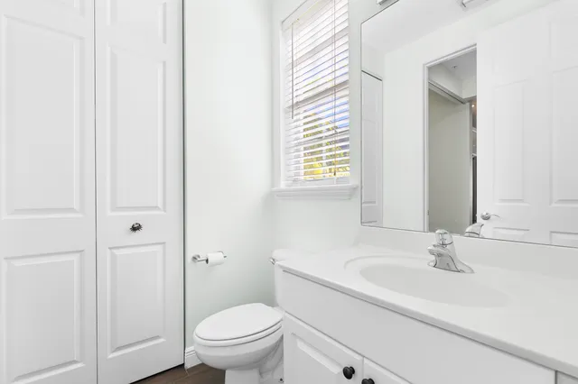 a bathroom with a sink a toilet and a window