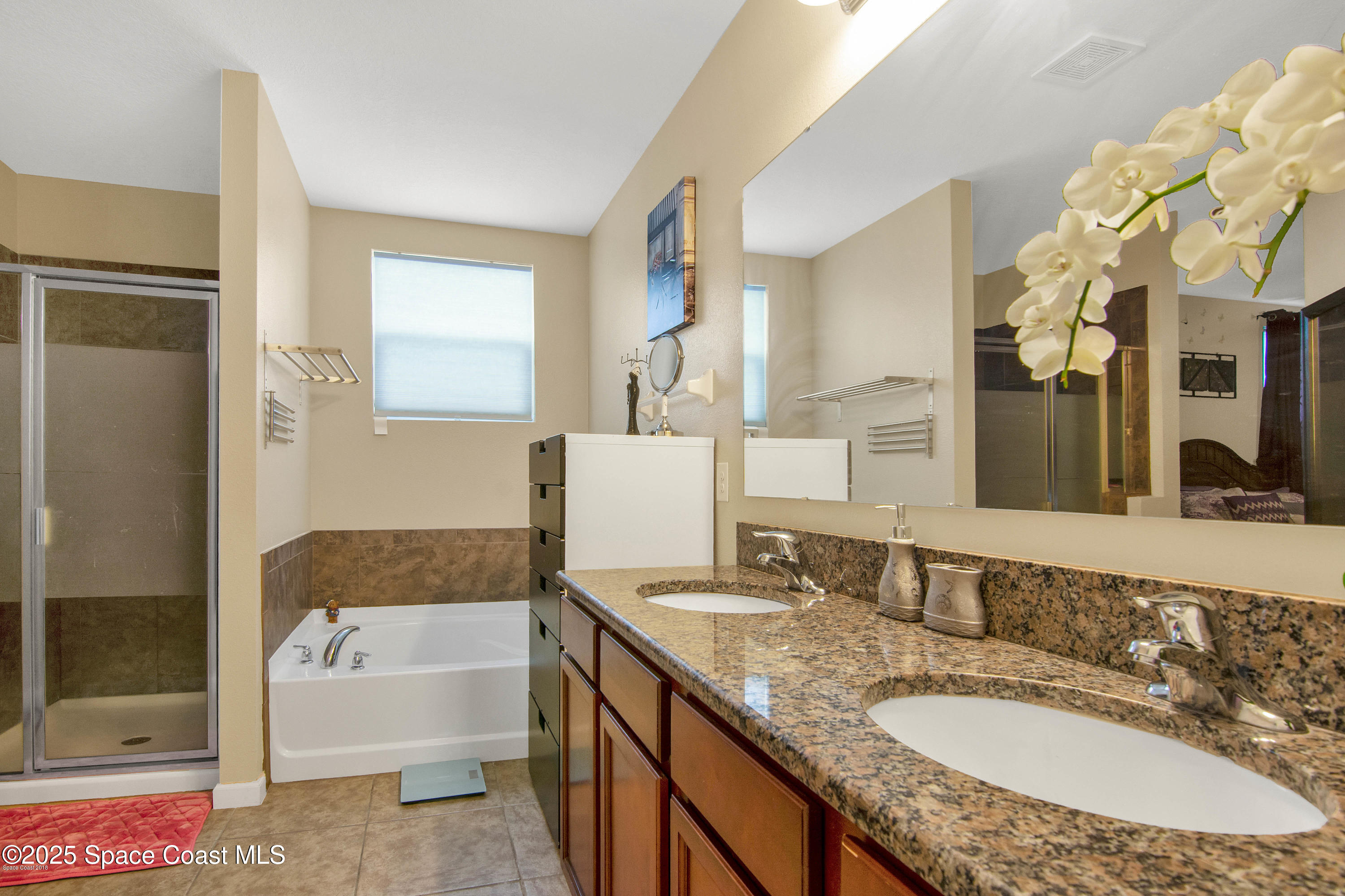 909 Fiddleleaf Circle Melbourne, FL 32904 - Photo 3 of 15 a bathroom with a granite countertop sink and a mirror