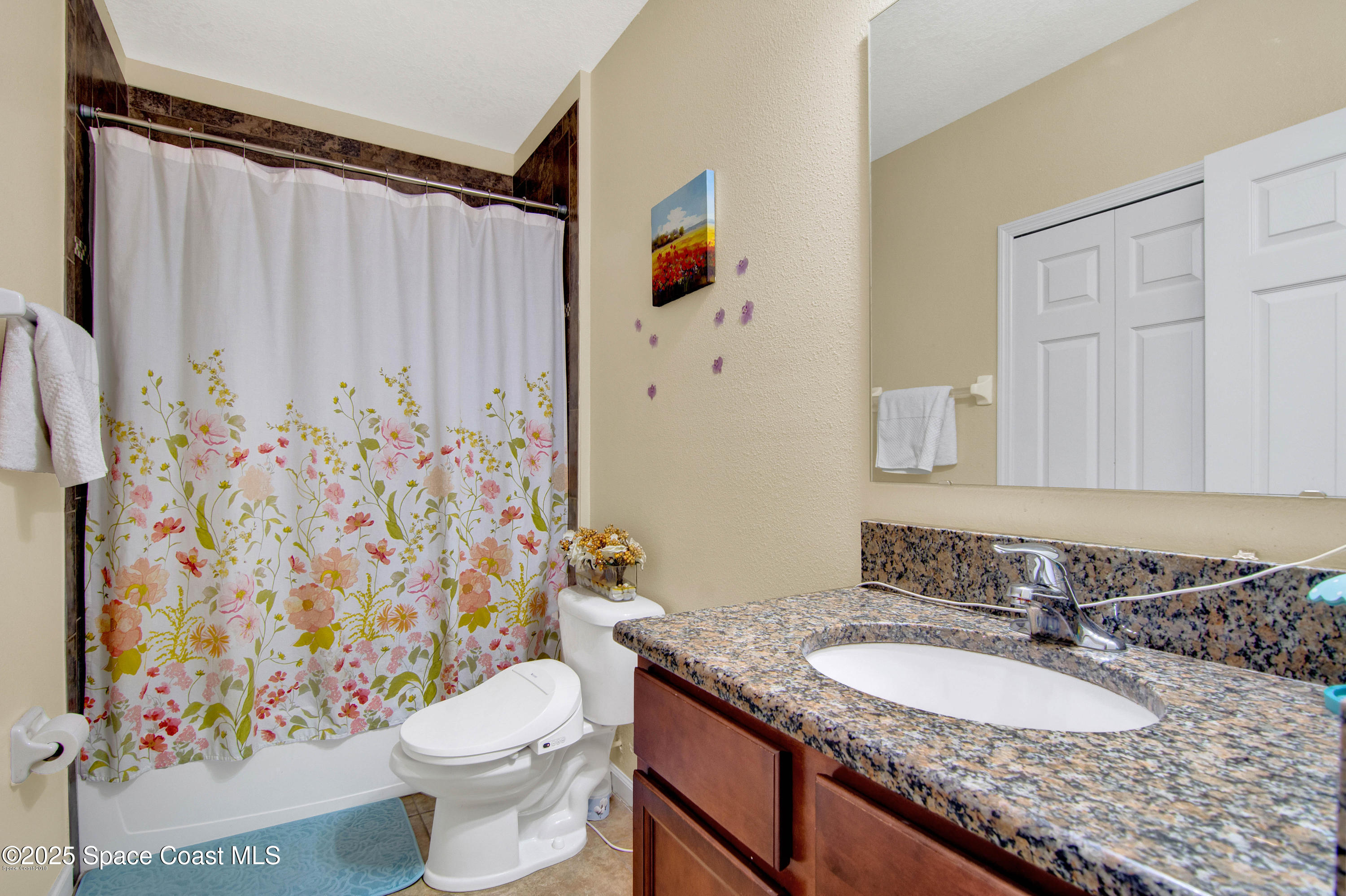 909 Fiddleleaf Circle Melbourne, FL 32904 - Photo 5 of 15 a bathroom with a granite countertop sink and a mirror