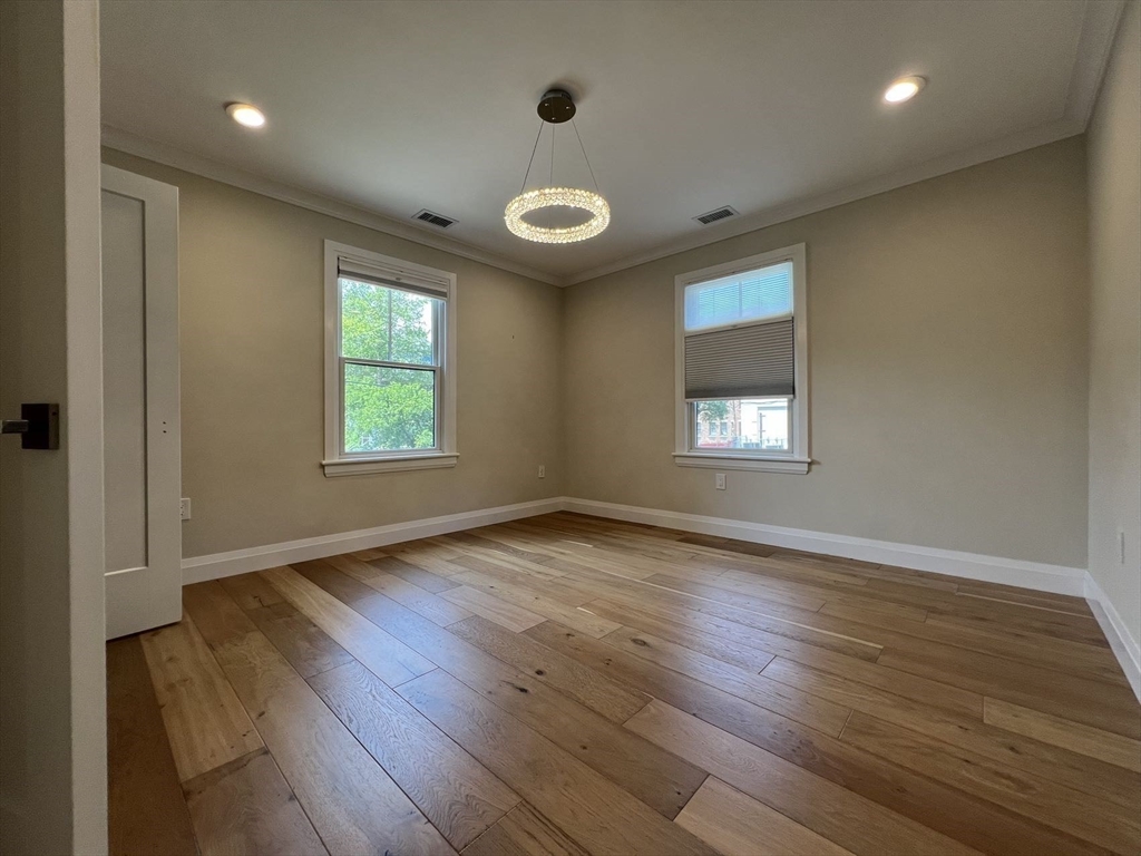 23 Winslow Road, Unit 1 Brookline, MA 02446 - Photo 11 of 27 an empty room with wooden floor and windows