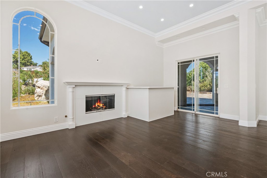 166 Dapplegray Road Bell Canyon, CA 91307 - Photo 6 of 57 an empty room with wooden floor a fireplace and windows