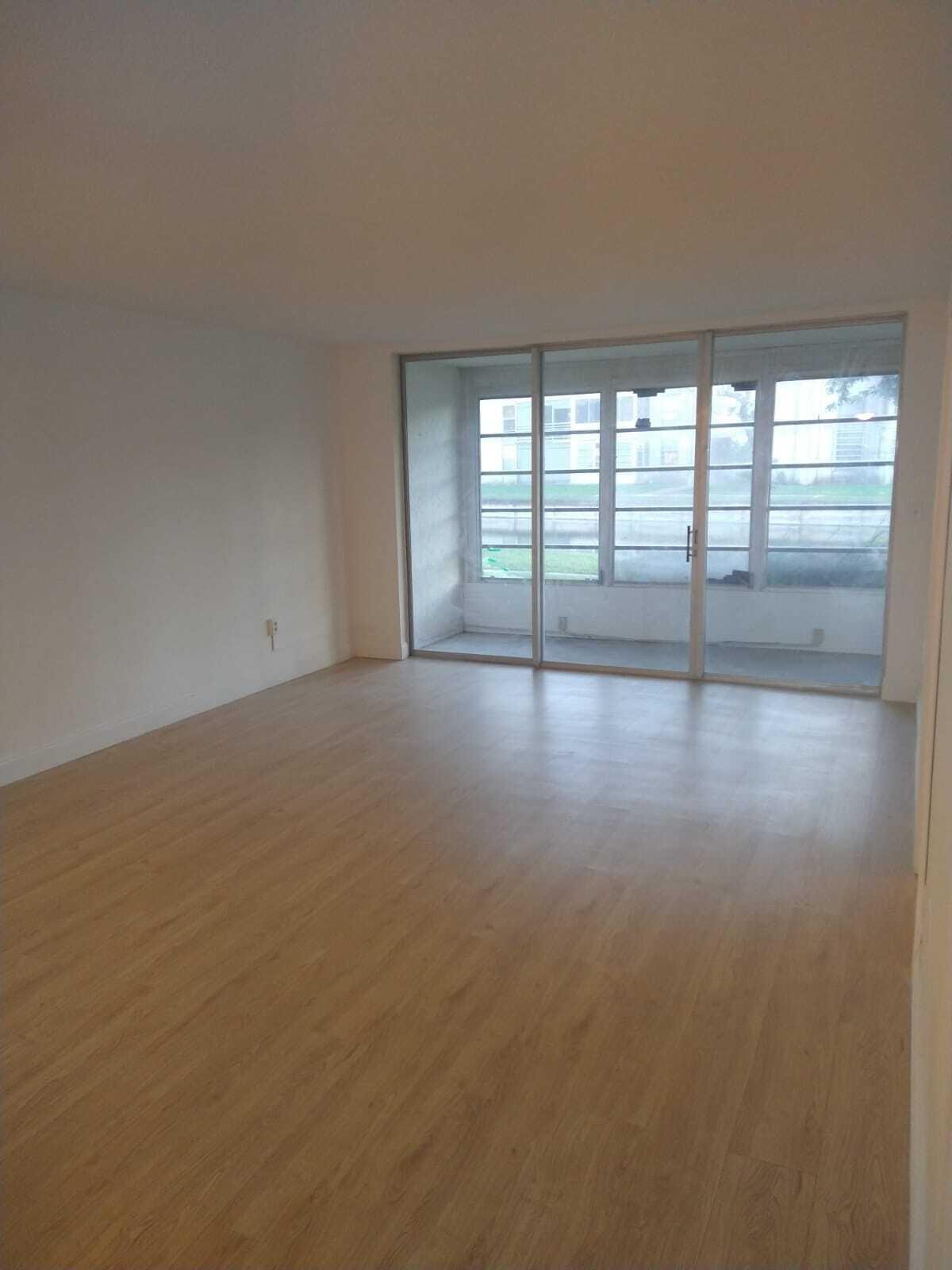8321 Sands Point Boulevard, Unit D109 Tamarac, FL 33321 - Photo 6 of 16 wooden floor in an empty room with a window