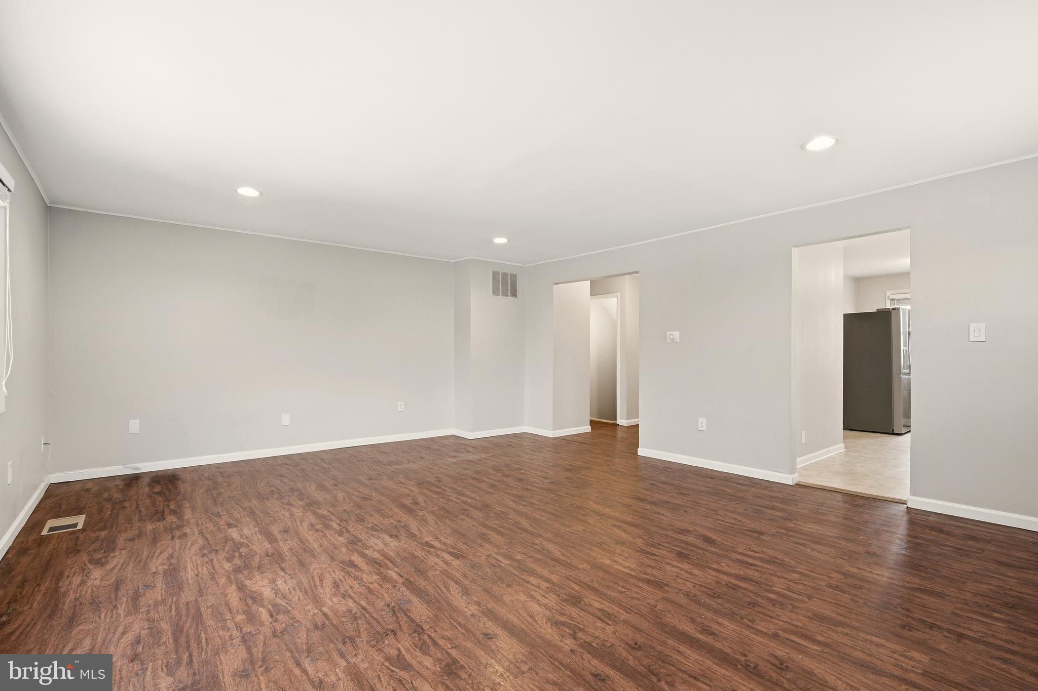 7712 Erica Lane Laurel, MD 20707 - Photo 11 of 35 a view of an empty room with wooden floor and a window