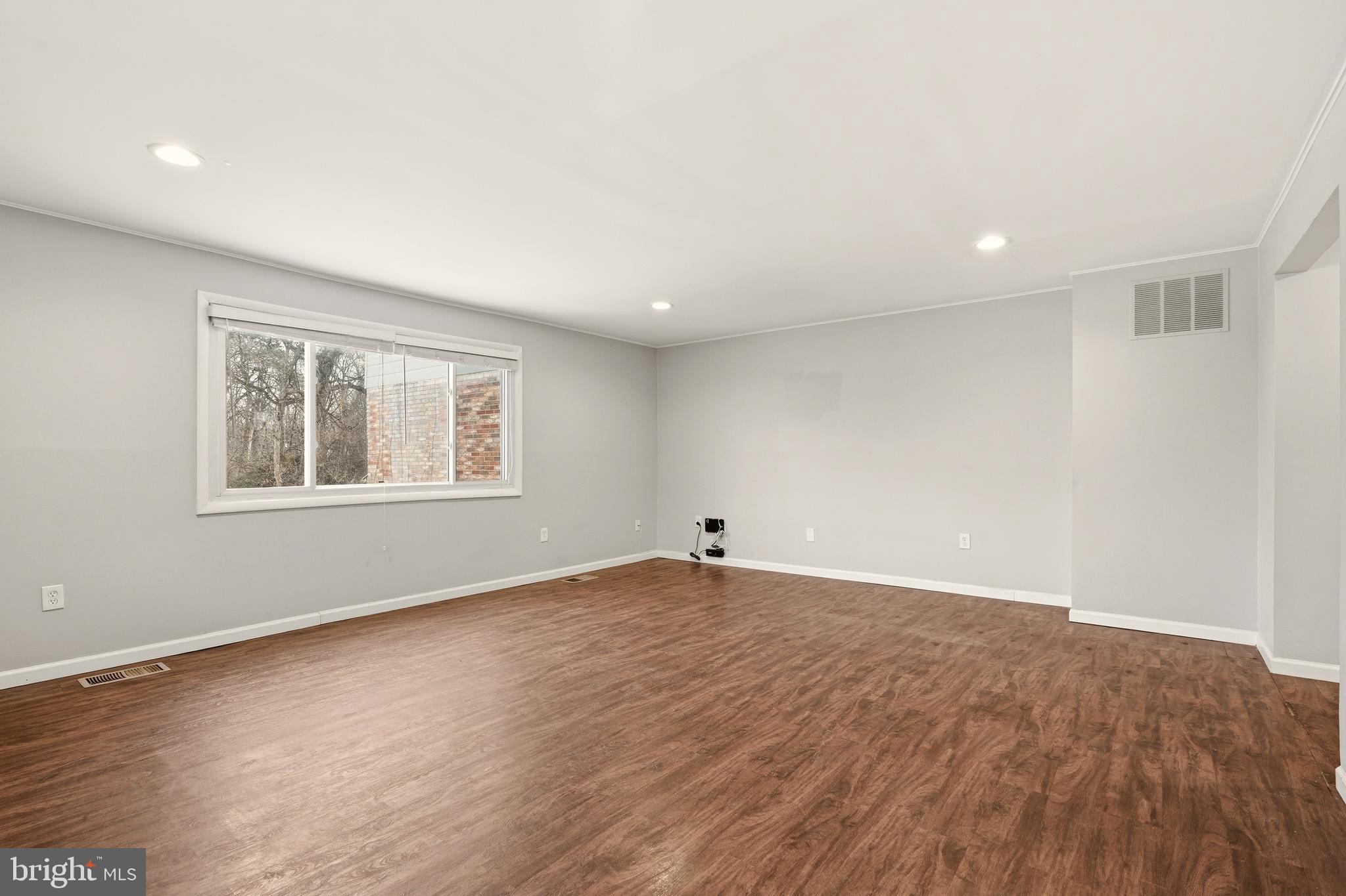 7712 Erica Lane Laurel, MD 20707 - Photo 12 of 35 an empty room with wooden floor and windows