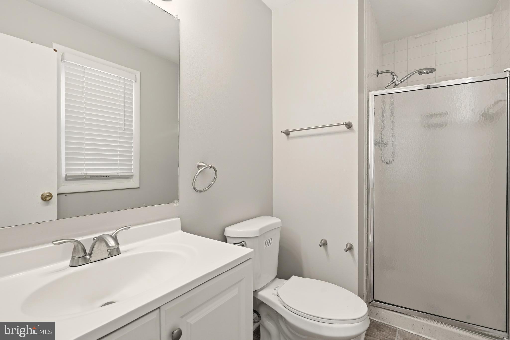 7712 Erica Lane Laurel, MD 20707 - Photo 19 of 35 a bathroom with a sink toilet vanity and shower