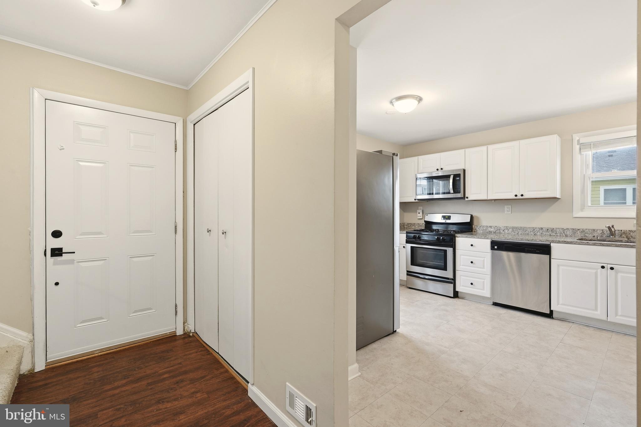 7712 Erica Lane Laurel, MD 20707 - Photo 6 of 35 a kitchen with white cabinets and stainless steel appliances