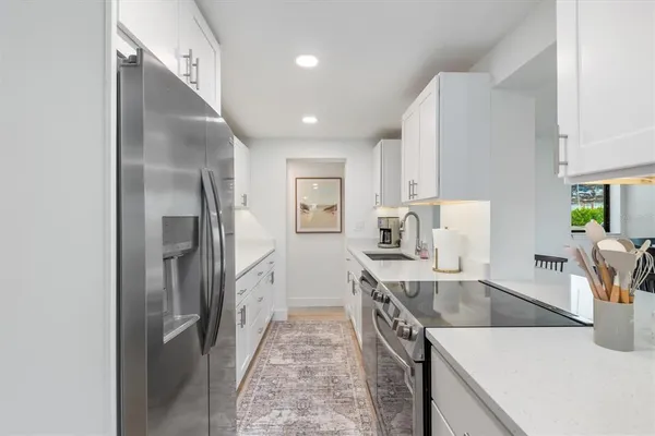 a kitchen with stainless steel appliances granite countertop a refrigerator and a sink