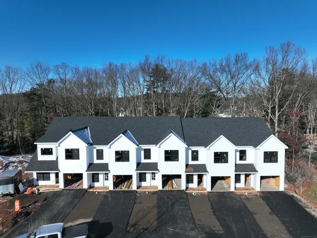a front view of residential houses with yard and green space