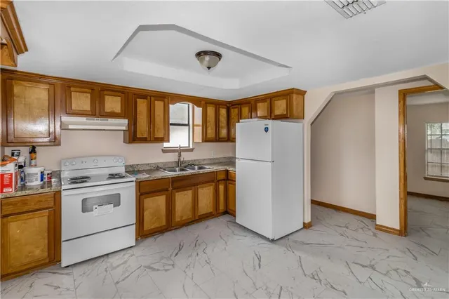 a kitchen with appliances a sink and a refrigerator
