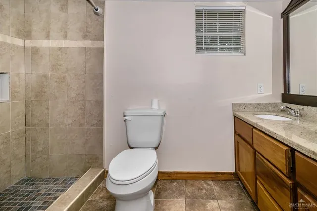 a bathroom with a granite countertop toilet and a sink