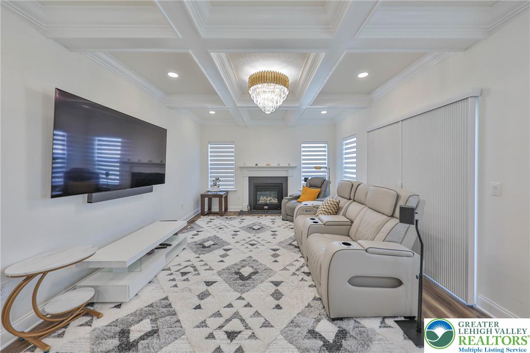 1105 Meco Road Easton, PA 18040 - Photo 30 of 100 An elegant coffered ceiling and built-in fireplace elevate this comfortable living space.