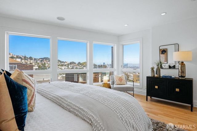 a bedroom with a bed and a large window