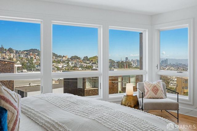 a bedroom with furniture and a large window