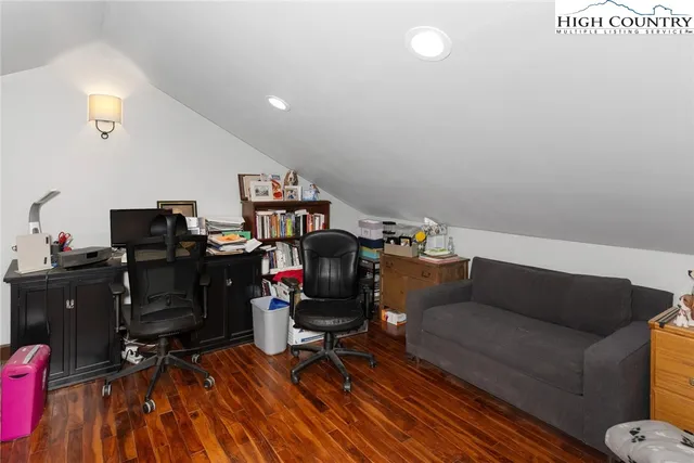 a living room with wooden floor furniture and a painting on the wall