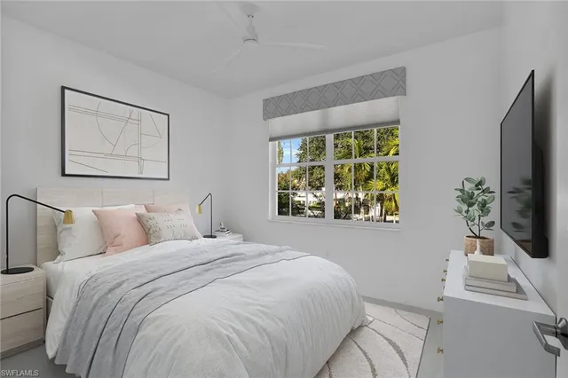 a bedroom with a bed and a flat tv screen on dresser