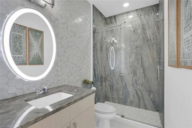 a bathroom with a granite countertop sink toilet and shower