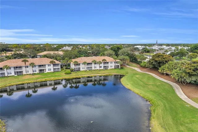 a view of a swimming pool with lawn chairs under an umbrella