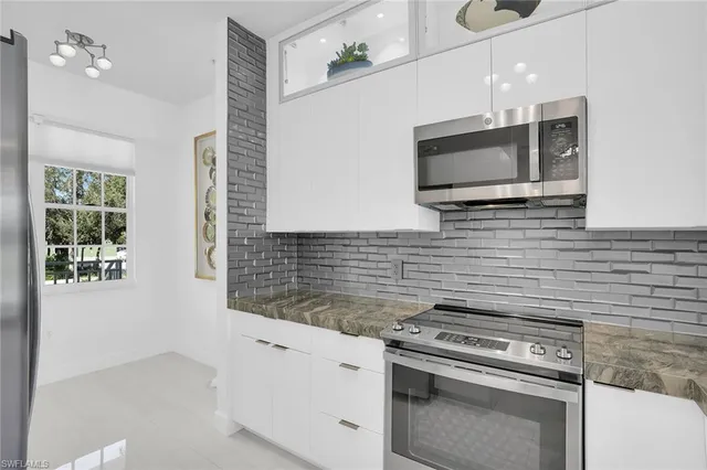 a kitchen with stainless steel appliances wooden cabinets and a stove top oven