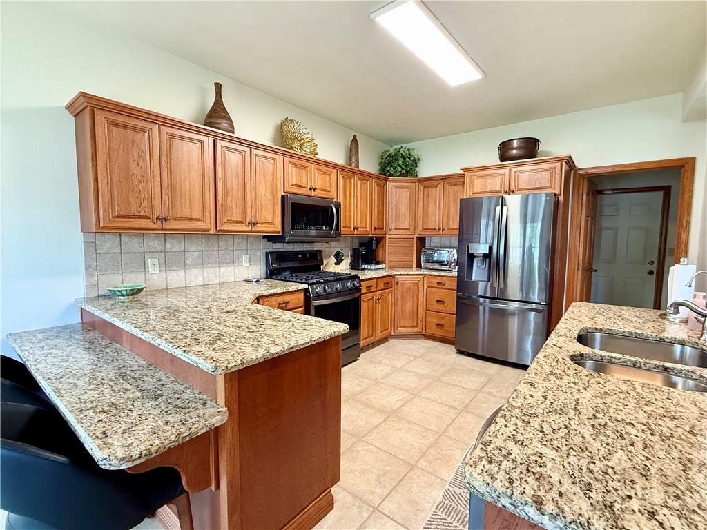 334 Manito Trail Mercer, PA 16137 - Photo 11 of 49 a kitchen with stainless steel appliances granite countertop a sink refrigerator and microwave